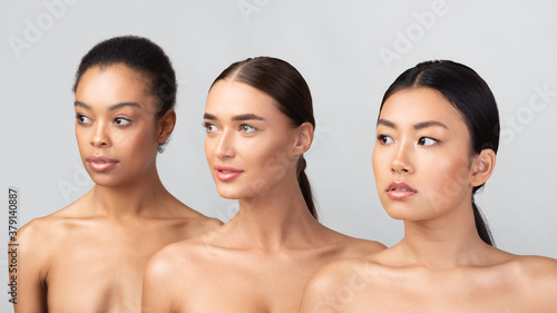 Portrait of three millennial women posing shirtless standing in studio