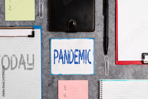 Word writing text Pandemic. Business photo showcasing occurring over a wide area affecting high proportion of population Paper accesories with digital smartphone arranged on different background photo