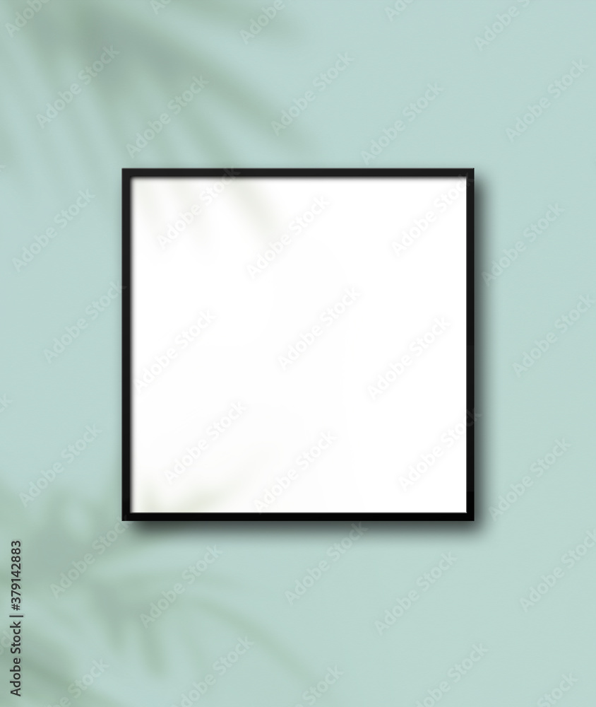 Black square picture frame hanging on a light blue wall Black square picture frame hanging on a light blue wall