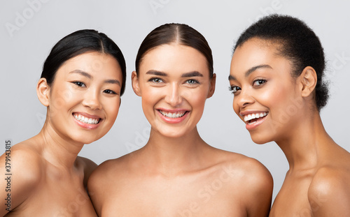 Three Diverse Models Women Smiling Posing Shirtless On Gray Background