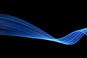 Long exposure photograph of neon blue colour in an abstract swirl, parallel lines pattern against a black background. Light painting photography.