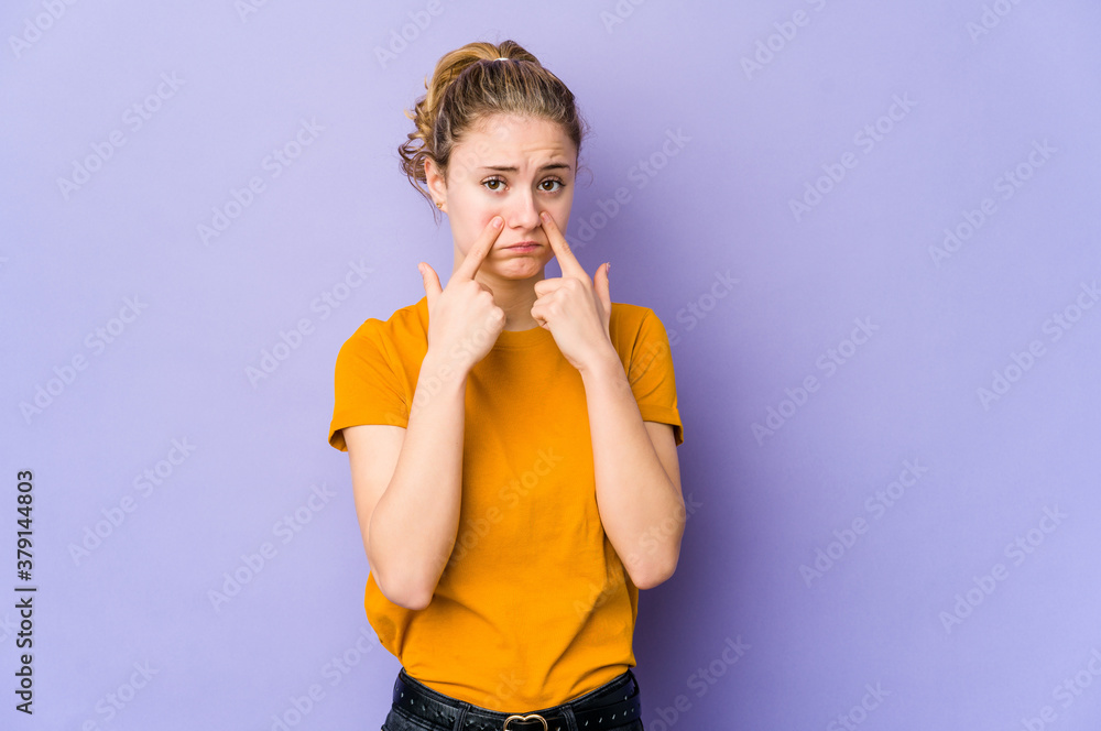 Young caucasian woman on purple background crying, unhappy with something, agony and confusion concept. Young caucasian woman on purple background crying, unhappy with something, agony and confusion concept.