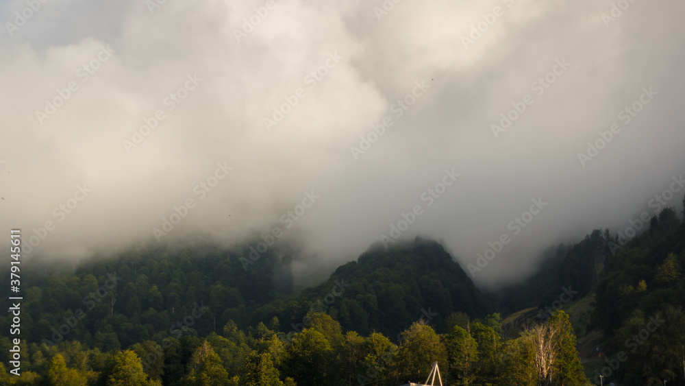 Obraz premium Misty mountain landscape with fir forest. Beautiful landscape with mountain view, cable car. Postcard view. Travel concept. Sunset, Golden hour