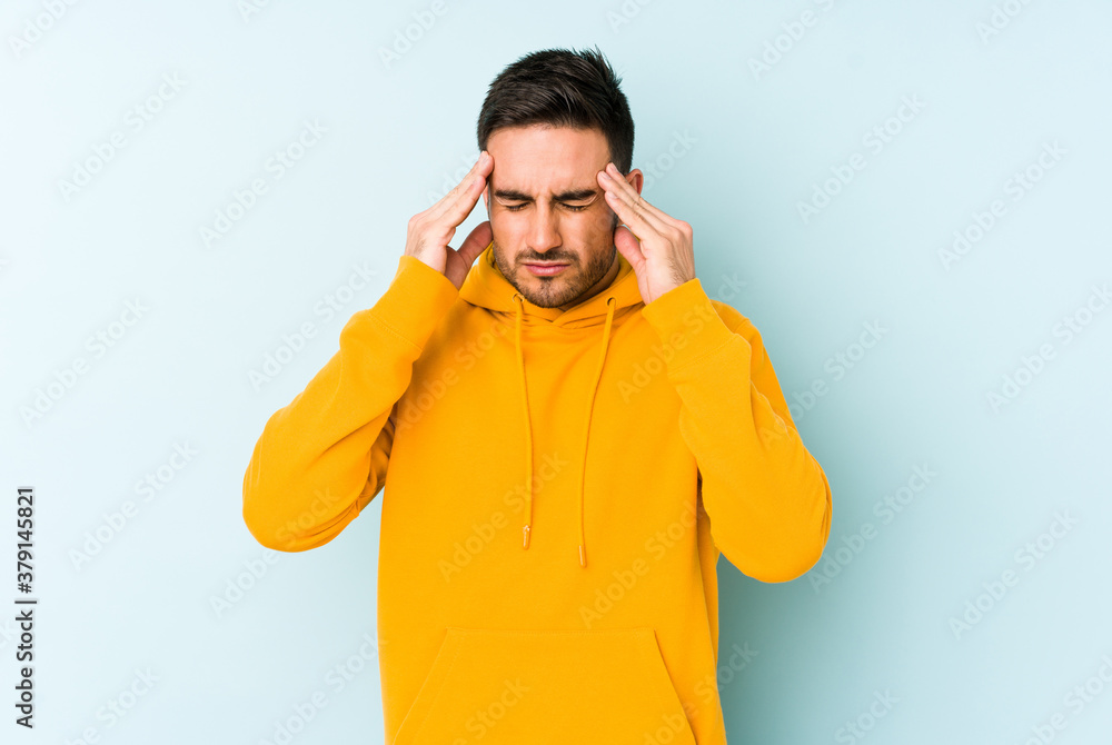 Young caucasian man isolated on blue background touching temples and having headache. Young caucasian man isolated on blue background touching temples and having headache.