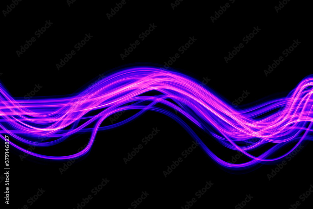 Obraz premium Long exposure photograph of purple neon colour in an abstract swirl, parallel lines pattern against a black background. Light painting photography.