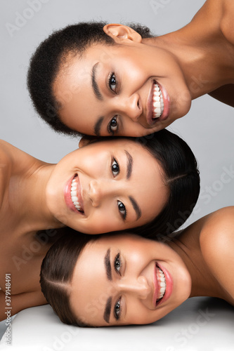 Three Diverse Women Posing Together Smiling On Gray Background, Vertical