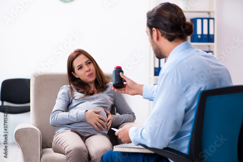 Pregnant woman visiting young male psychologist