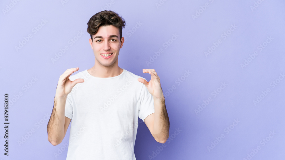 Young caucasian man isolated on purple background holding something with palms, offering to camera. Young caucasian man isolated on purple background holding something with palms, offering to camera.