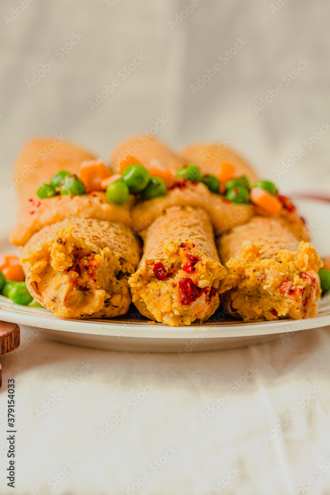 Vegetarian crepes made of buckwheat and chickpea flour with sauce, red paprika, sweet corn and green peas Vegetarian crepes made of buckwheat and chickpea flour with sauce, red paprika, sweet corn and green peas