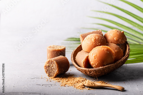 Different shape of organic brown palm sugar on grey concrete background. photo