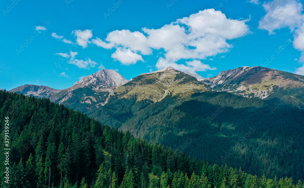 Fototapeta premium Amazing colorful alpine rocky mountain. Himalaya mountain range. Summer, green forest and hills. Fog clouds.