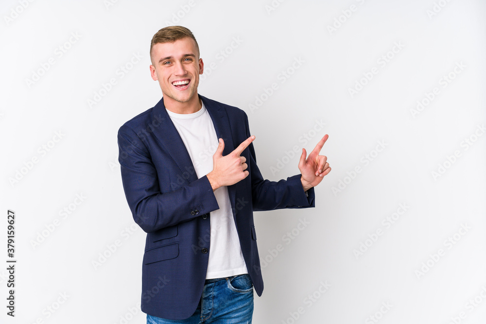 Young business caucasian man pointing with forefingers to a copy space, expressing excitement and desire. Young business caucasian man pointing with forefingers to a copy space, expressing excitement and desire.