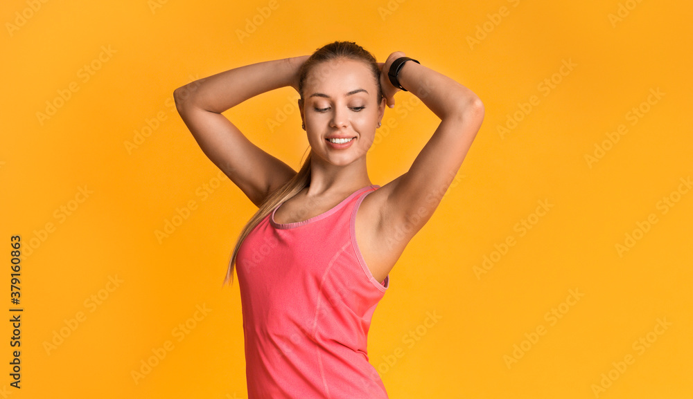 Beautiful fitness model with perfect sporty body posing on yellow background Beautiful fitness model with perfect sporty body posing on yellow background