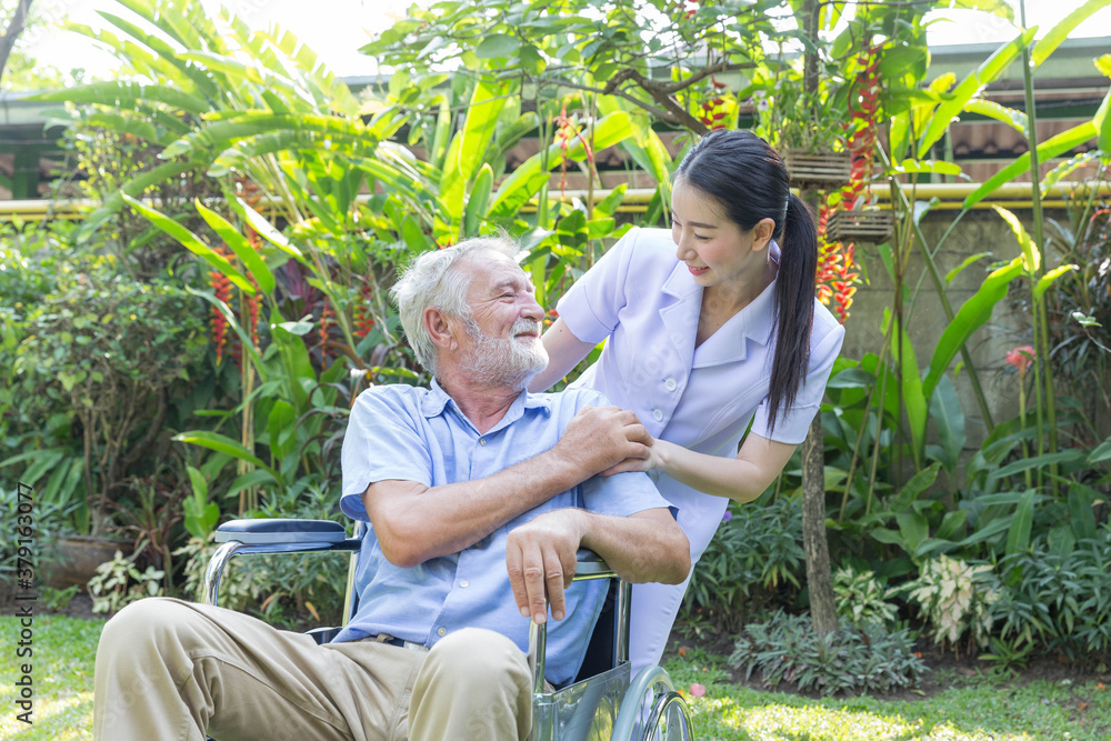 A nurse take care a senior male on wheelchair in his garden at home A nurse take care a senior male on wheelchair in his garden at home