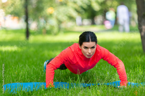 Woman doing a push up exercises in city park