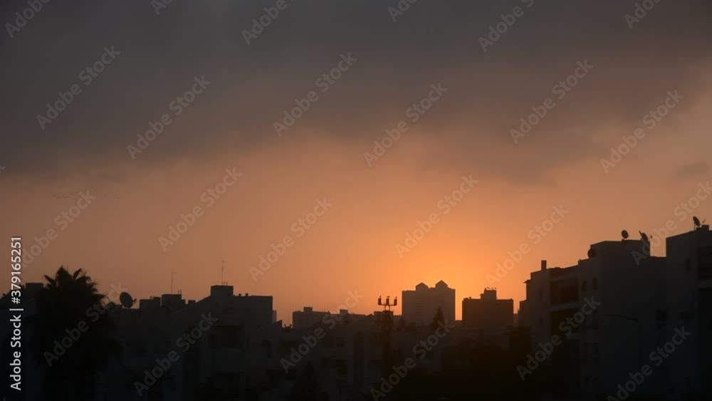 beautiful sunrise on the background of silhouettes of houses beautiful sunrise on the background of silhouettes of houses