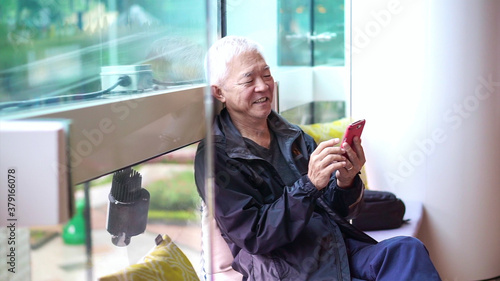 Canvas Print Asian senior man using smartphone outside in public space store happy connecting