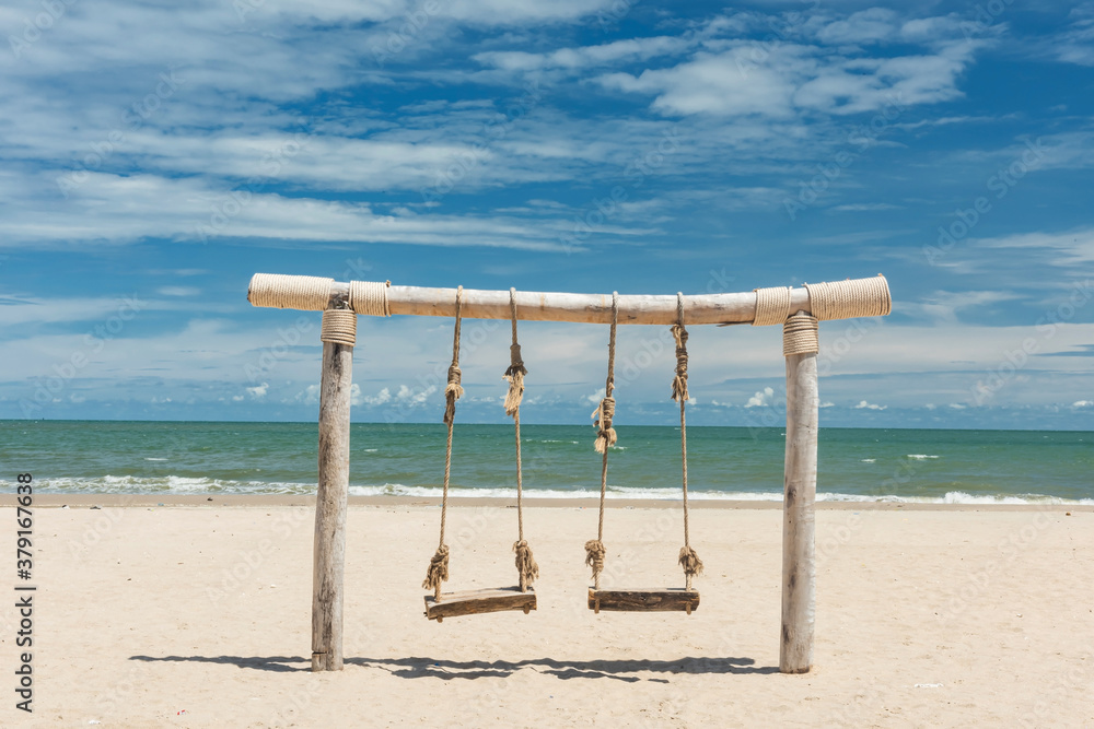 Wooden rope swing on beach in summer Wooden rope swing on beach in summer