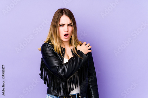 Young caucasian woman isolated on purple background having a shoulder pain.