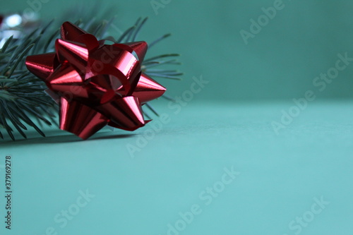 bow for a holiday gift with a branch of spruce pine on a green background close up with copy space new year Christmas