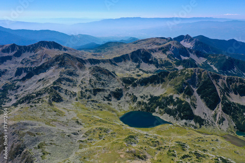 Amazing alpine lake at the mountains, high alpine green peak, sunny summer day, drone flight.