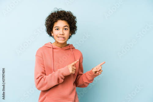 African american little boy isolated shocked pointing with index fingers to a copy space.