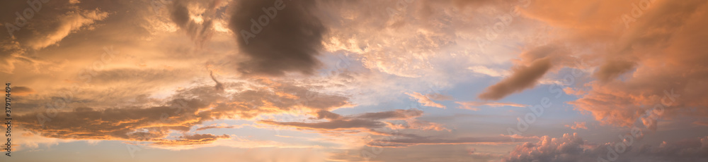 wide sunset sky panorama with yellow gray and orange clouds
