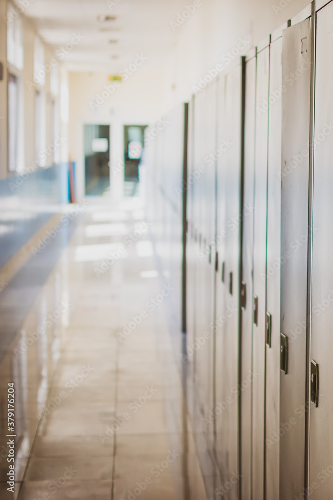 Empty hallway corridor of a high school or college closed during COVID-19 (Coronavirus). Locers blurred into lonley hallway.