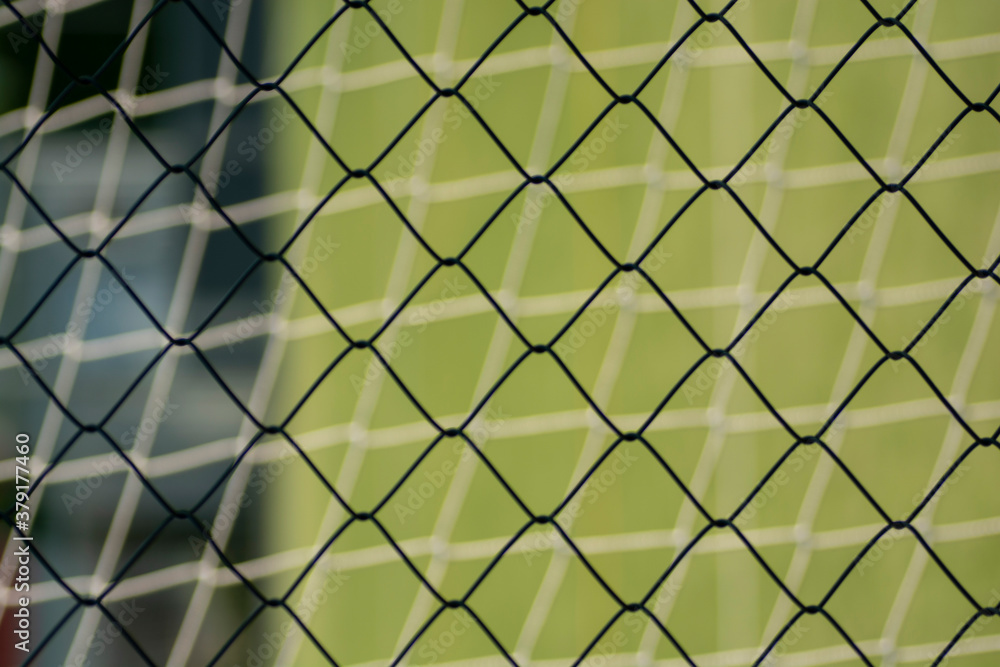 Football or Soccer net blend together with Metal fence net close up . Texture . Pattern. Background. Football or Soccer net blend together with Metal fence net close up . Texture . Pattern. Background.