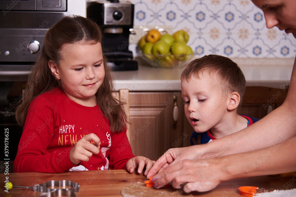 Fototapeta premium brother and sister prepare homemade cookies in the kitchen. The mood of the occasion. Fun and laughter