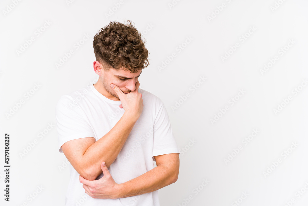 Young blond curly hair caucasian man isolated looking sideways with doubtful and skeptical expression. Young blond curly hair caucasian man isolated looking sideways with doubtful and skeptical expression.