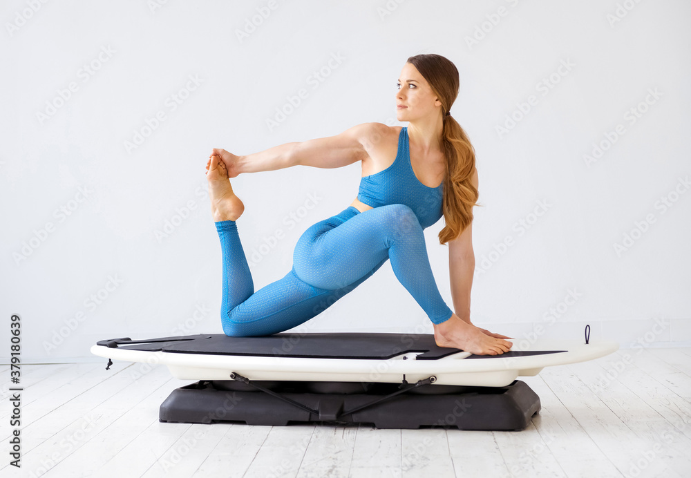 Obraz premium Young woman doing hamstring stretching exercises