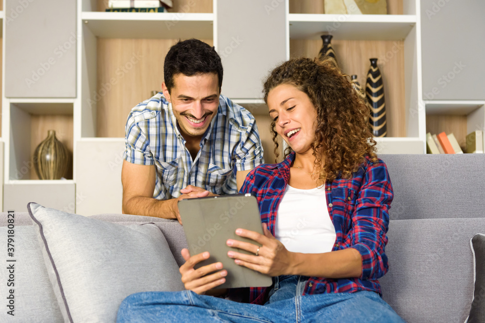 Happy young couple watching media on a tablet Happy young couple watching media on a tablet
