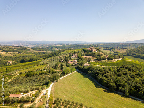 Aerial/Drone Panorama of Tuscany Landscape with vineyards and olive trees - With Montauto castle and San Gimignano - Italy