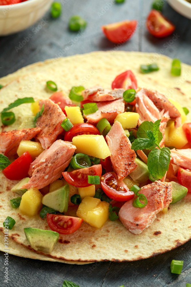 Salmon fish tacos with mango, avocado, tomato, spring onion and lime. Mexican food Salmon fish tacos with mango, avocado, tomato, spring onion and lime. Mexican food