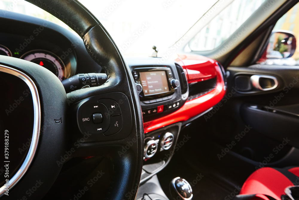Modern black steering wheel with multifunction buttons for quick control, close-up in the car. Shallow dof.