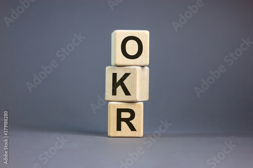 Concept word 'OKR' on wooden cubes on a beautiful grey background. Business concept, copy space.