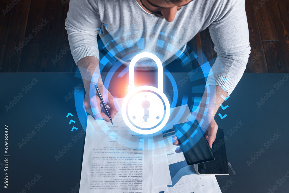 Obraz premium Handsome man working on Data protection project. Multiexposure. Lock icon hologram.