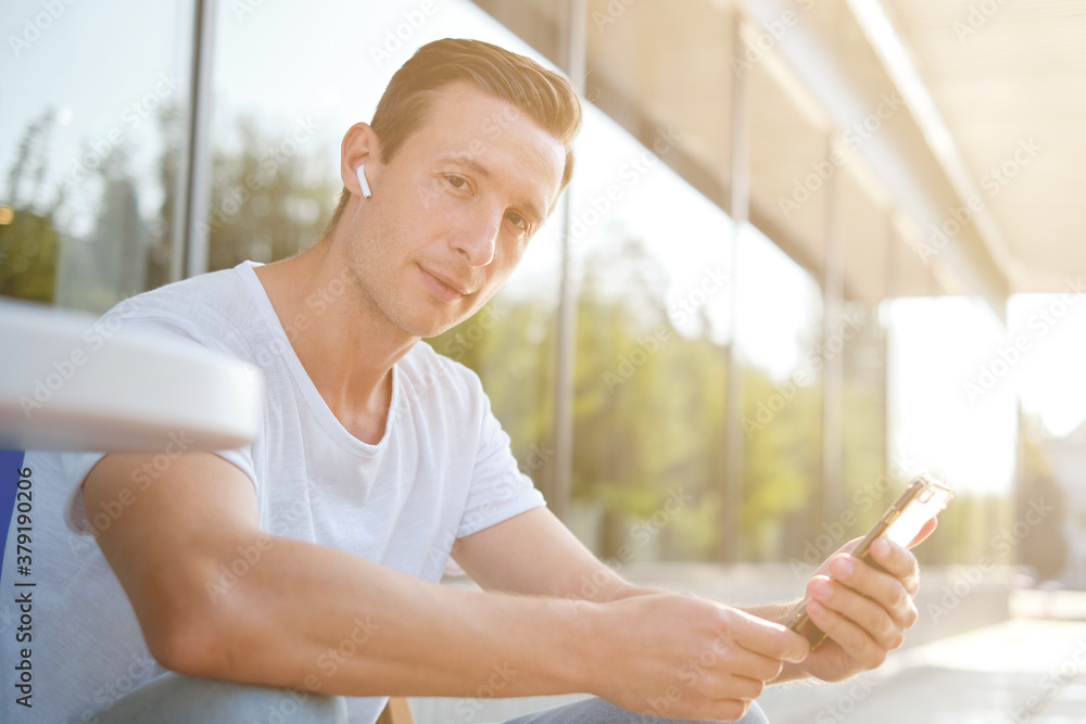 Young attractive man enjoying a cup of aromatic coffee outdoors in sunny weather Young attractive man enjoying a cup of aromatic coffee outdoors in sunny weather
