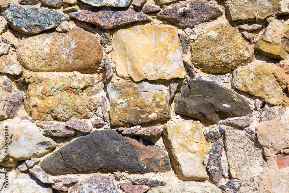 Old uneven, rough, irregular granite stone wall. Natural textured background. Old uneven, rough, irregular granite stone wall. Natural textured background.