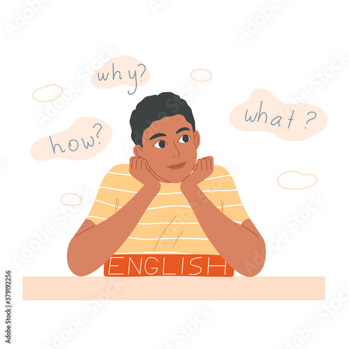Boy sits at the desk and does his homework.