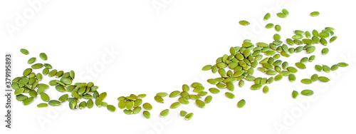 Pumpkin seeds in a row isolated on white background. Pile of green seeds