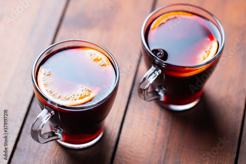 Mulled wine on wooden background. Winter drink traditional for the Christmas holidays. Two glasses of Christmas mulled wine with oranges