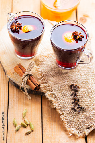 Mulled wine on a wooden background. Autumn mulled wine and spices on burlap. Christmas hot drink in rustic style