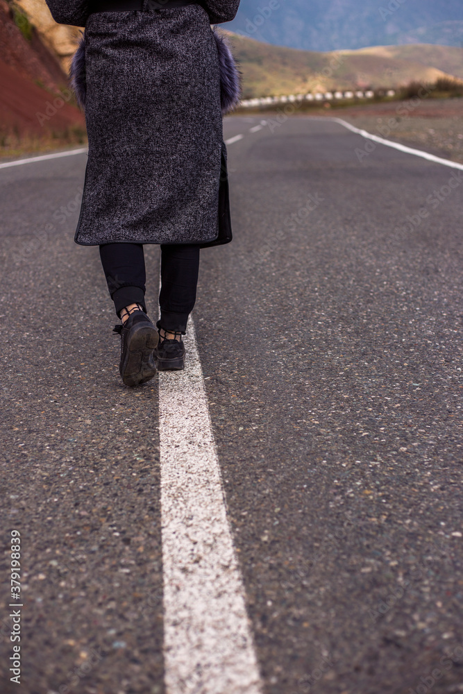 woman walking on a asphalt road