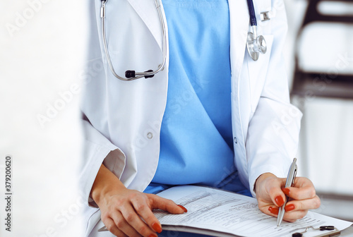 Woman - doctor consults her female patient while using clipboard and medication history record. Medicine concept