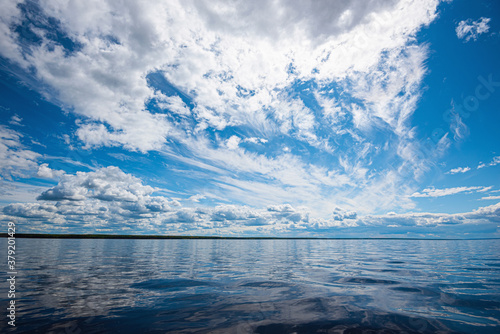 Panorama of calm lake, Kama river blue sky with clouds reflected in the water. photo