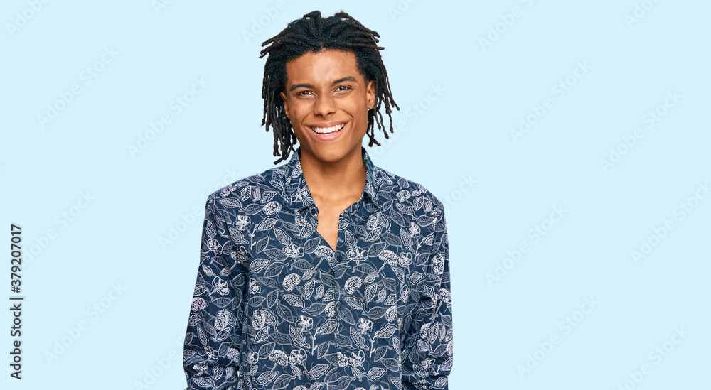 Young african american man wearing 80s shirt looking positive and happy standing and smiling with a confident smile showing teeth Young african american man wearing 80s shirt looking positive and happy standing and smiling with a confident smile showing teeth