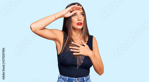 Young hispanic woman wearing casual clothes touching forehead for illness and fever, flu and cold, virus sick
