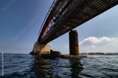 Old huge abandoned rusty bridge above water. Coast. Summer. bridge above the sea. background